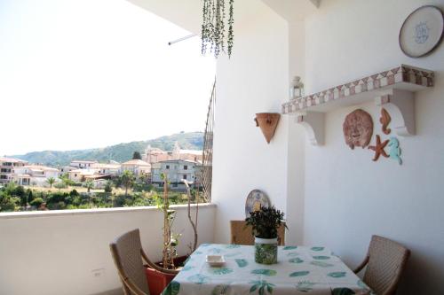 tavolo e sedie in una stanza con finestra di Casa Peonia a Tropea