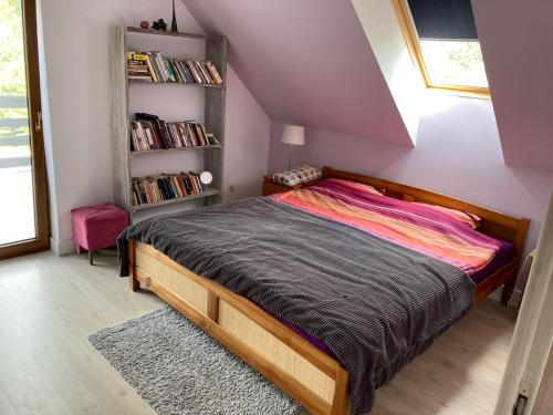 a bedroom with a bed and a book shelf at Domek rodzinny nad jeziorem Kątno Mazury in Kątno