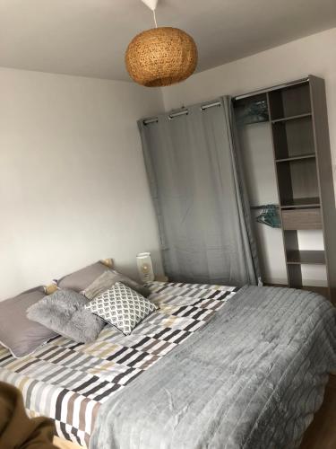 a bedroom with a bed and a lamp at Appartement Dunkerque proximité plage et centre ville in Dunkerque