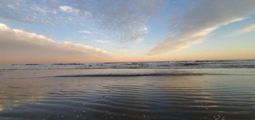 uma vista para o oceano a partir da praia ao pôr-do-sol em Casa de Praia com piscina - Itanhaém em Itanhaém