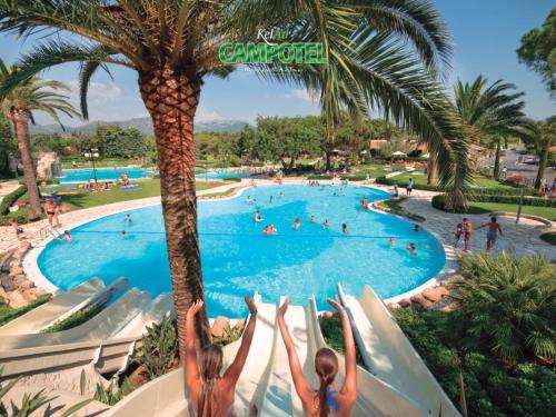 two girls are going down a water slide at a resort at Mobile Homes by KelAir at Playa Montroig Camping Resort in Tarragona