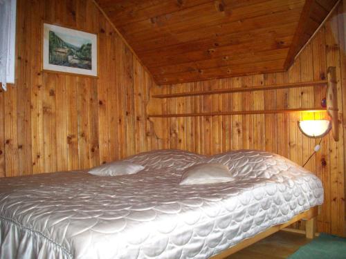 1 dormitorio con 1 cama en una pared de madera en Cabana Bavaria, en Sovata