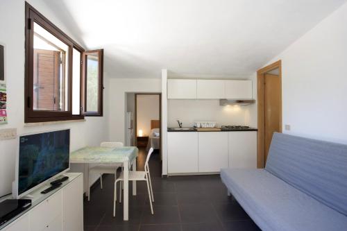 サン・ヴィート・ロ・カーポにあるVilletta Blusanvitoのベッド、テーブル、キッチンが備わる客室です。