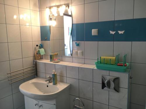 uma casa de banho com um lavatório e um espelho em Kapitańskie Gniazdo em Czaplinek