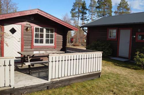a small cabin with a picnic table on a deck at Cosy non smoking Cabin close to beach,Alnö in Sundsvall