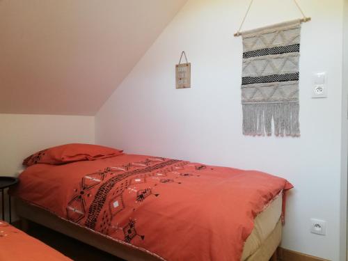 - une chambre avec un lit doté de draps rouges et une fenêtre dans l'établissement * Maison aux portes de Troyes en Champagne *, à Sainte-Maure