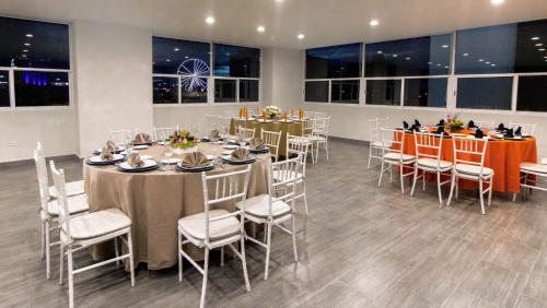 a dining room with tables and chairs and windows at Mision Puebla Angelopolis in Puebla