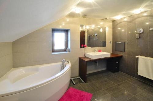 a large bathroom with a large tub and a sink at Willa Dom wakacyjny Zakątek in Kołobrzeg