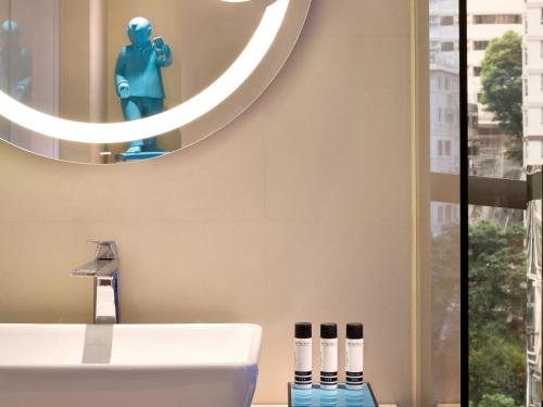 a bathroom with a sink and a mirror at Hotel Indigo Hong Kong Island by IHG in Hong Kong