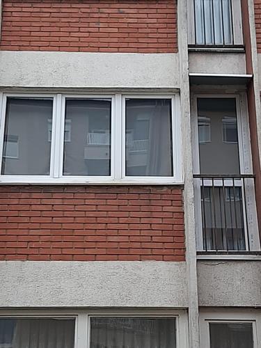 a brick building with three windows on it at Apartman Maja in Bijeljina