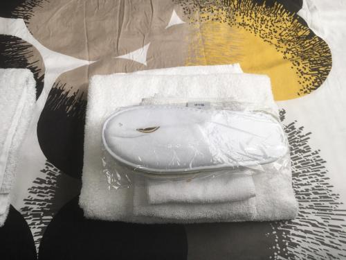 a white purse sitting on a pile of towels at Design BB Bed&Bike holiday cottage Tiny Home in Spakenburg in Spakenburg
