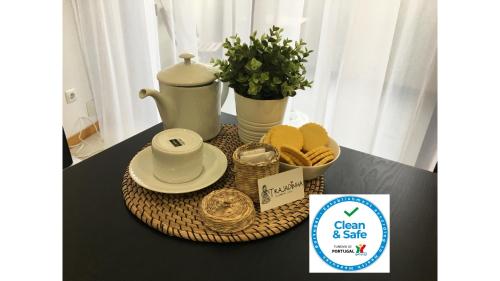a table with a tray with a tea kettle and cookies at Trajadinha in Vila Praia de Âncora