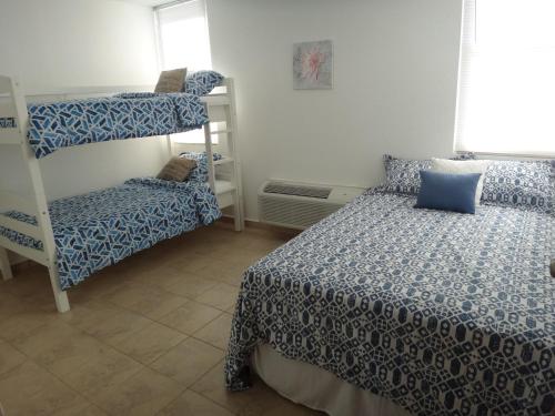 a bedroom with two bunk beds and a chair at Stunning Sunset View, Walking distance to private beach in Cabo Rojo