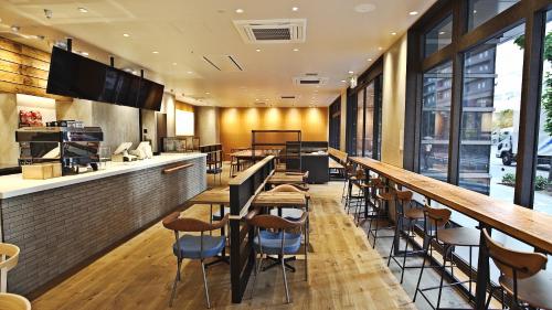 a bar with wooden tables and chairs in a restaurant at Welina Hotel Premier Nakanoshima EAST in Osaka