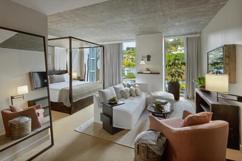 a living room with a white couch and a bedroom at 1 Hotel West Hollywood in Los Angeles