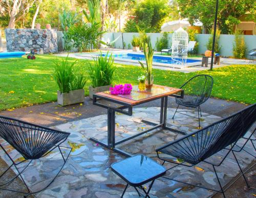 eine Terrasse mit einem Tisch und Stühlen auf einer Steinterrasse in der Unterkunft Htl & Villas Comala, alberca , parking, céntricas, Petfriendly in Comala