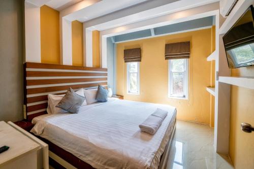 a bedroom with a large bed with two pillows on it at The Train Resort in Jomtien Beach