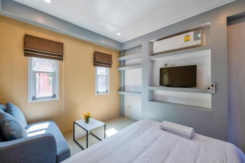 a room with a bed and a tv on a wall at The Train Resort in Jomtien Beach