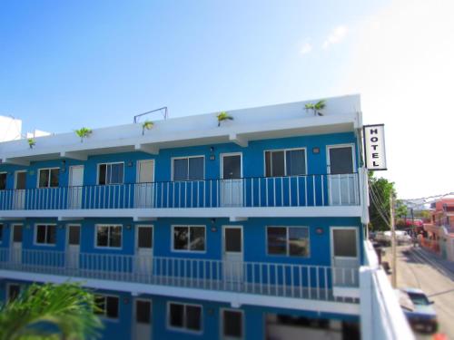 a blue building with a balcony on a street at Blue Coconut Cancun Hotel in Cancún