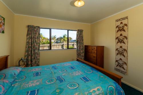 En eller flere senge i et værelse på Ahiparadise - Ahipara Holiday Home