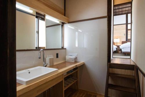 a bathroom with a sink and a mirror at 鞆猫庵 Tomo Nyahn in Fukuyama