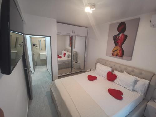 a bedroom with a bed with two red hearts on it at MaraVali Seaview Mamaia in Mamaia