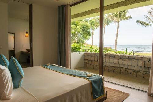 a bedroom with a bed and a view of the ocean at Mia Resort Nha Trang in Nha Trang