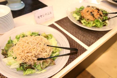 two plates of food on a table with noodles at Nishiizu Crystal View Hotel in Nishiizu