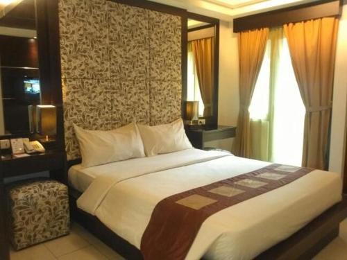 una camera con un grande letto e una finestra di Metro Hotel Jababeka a Cikarang