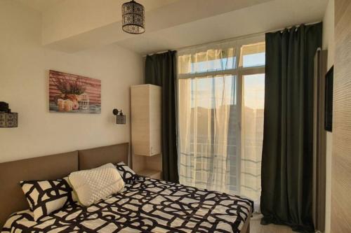 una camera da letto con un letto e una grande finestra di ZIAN'S Studio Mamaia Nord Beach Resort a Mamaia Nord - Năvodari