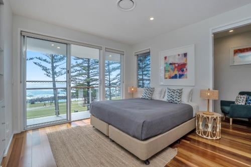 a bedroom with a bed and a view of the ocean at Bujerum Apartments on Burleigh in Gold Coast