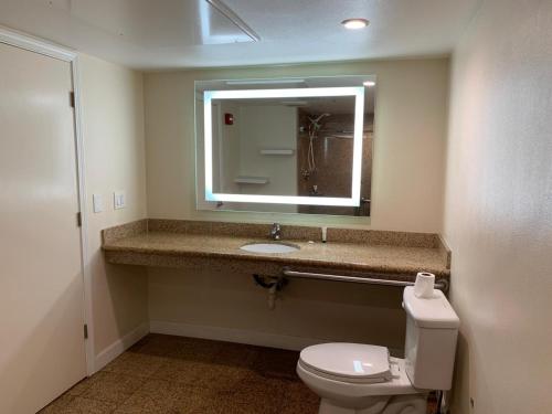 a bathroom with a toilet and a sink and a mirror at Motel 6 Vallejo, CA - Napa Valley in Vallejo