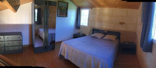 een kleine slaapkamer met een bed en een spiegel bij Gites Lacale face à la rivière in Vignonet