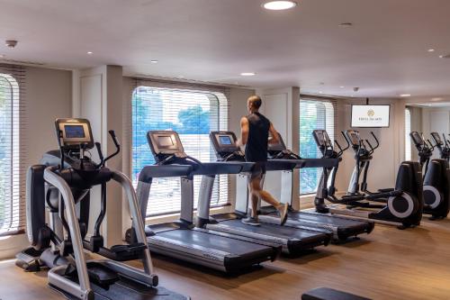 a man walking on a treadmill in a gym at Hotel Des Arts Saigon Mgallery Collection in Ho Chi Minh City