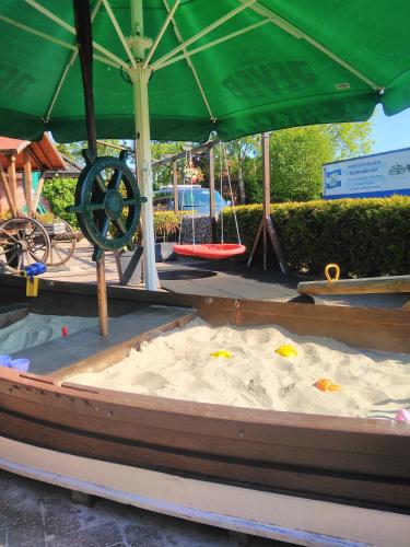a sandpit with a wheel in the middle of a sandbox at Hotel Rüstersieler Hof in Wilhelmshaven