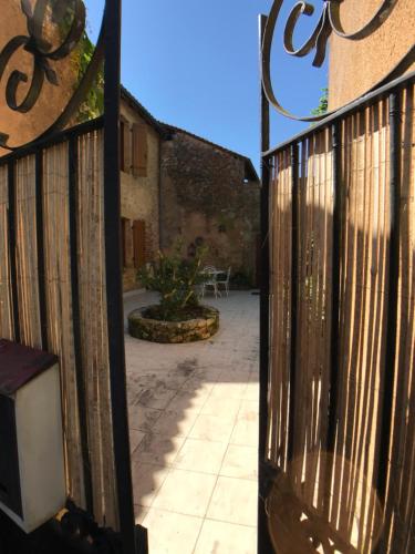 an open gate to a patio with a courtyard at villa Marguerite terrasse & garage in Belvès