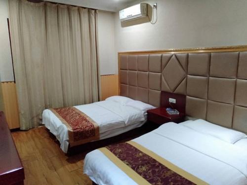 a hotel room with two beds and a window at Xi'an Helen Apartment in Xi'an