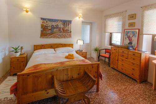 a bedroom with a large wooden bed and a desk at b&b Antiche Pietre in Bollengo