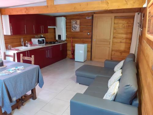 - une cuisine et un salon avec un canapé bleu et une table dans l'établissement Gite de Haute Saintonge à Crazannes, à Crazannes