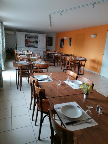 a dining room with wooden tables and chairs at Hôtel Bar des Arènes in Pontonx-sur-lʼAdour
