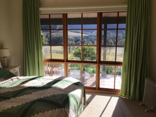 a bedroom with a large window with a view at Tantallon in Berry