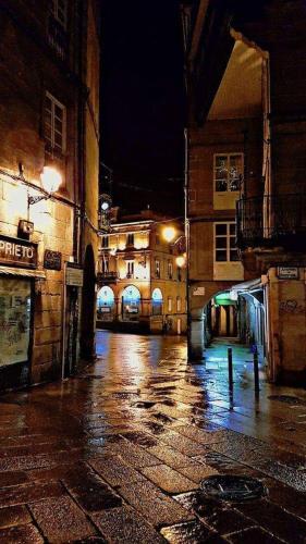 an empty city street at night with buildings at Motel Cancun Barbadas-Ourense in Os Fornos