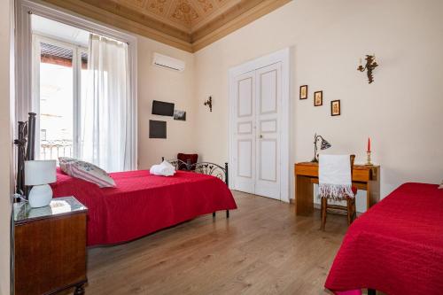 a bedroom with two beds and a desk and a window at Acanthus B&B in Catania