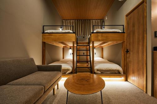 a living room with a couch and two bunk beds at mizuka Imaizumi 2 - unmanned hotel - in Fukuoka