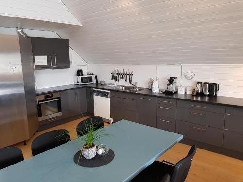 Utsira的住宿－Utsira Overnatting - Sildaloftet，厨房配有蓝色的桌子和台面