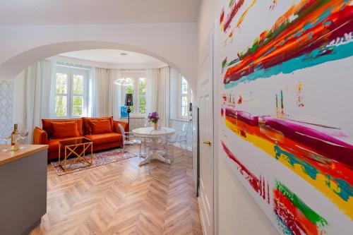 a living room with a colorful painting on the wall at Luksusowy Apartament Turkusowa Szafa 300 metrów od Plaży Mielno in Mielno