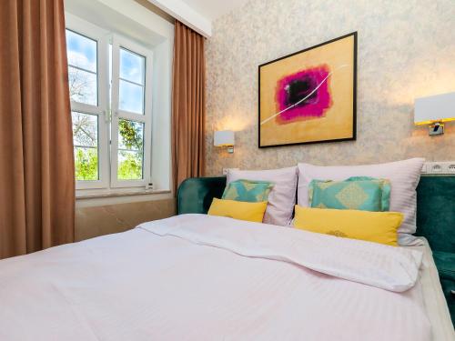 a bedroom with a large white bed with yellow pillows at Luksusowy Apartament Turkusowa Szafa 300 metrów od Plaży Mielno in Mielno