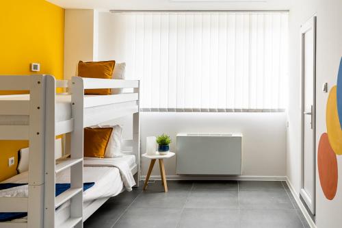 a bedroom with bunk beds and a yellow wall at Kostovski Rooms-near E75 to Greece in Veles
