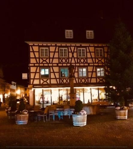 a building with a table and chairs in front of it at Cafe Restaurant Rohan in Ettenheim