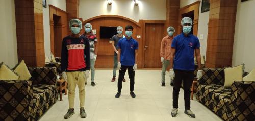 a group of men standing in a room wearing masks at Hotel Krishna Ji in Haridwār